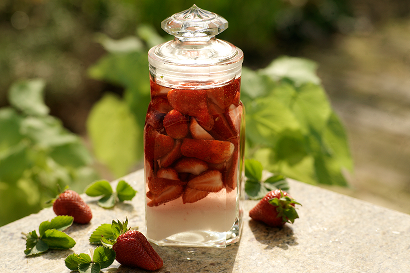 Aardbeien en likeur in glazen fles